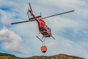 red helicopter carrying water